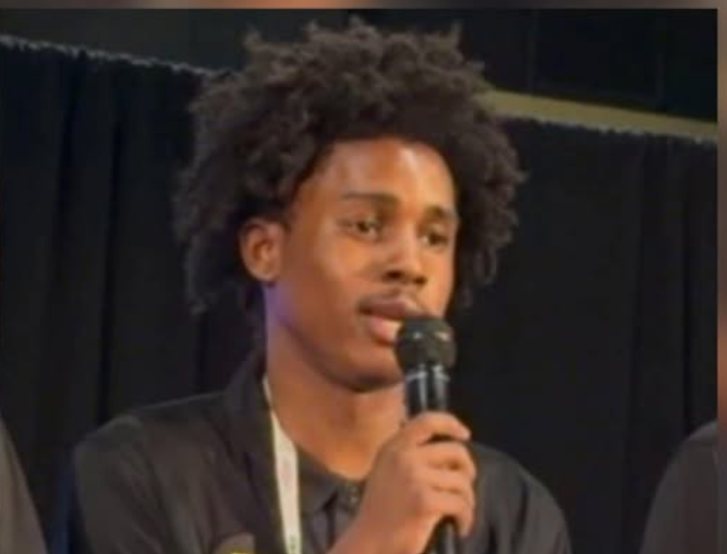 David Anderson speaking into a microphone on stage
