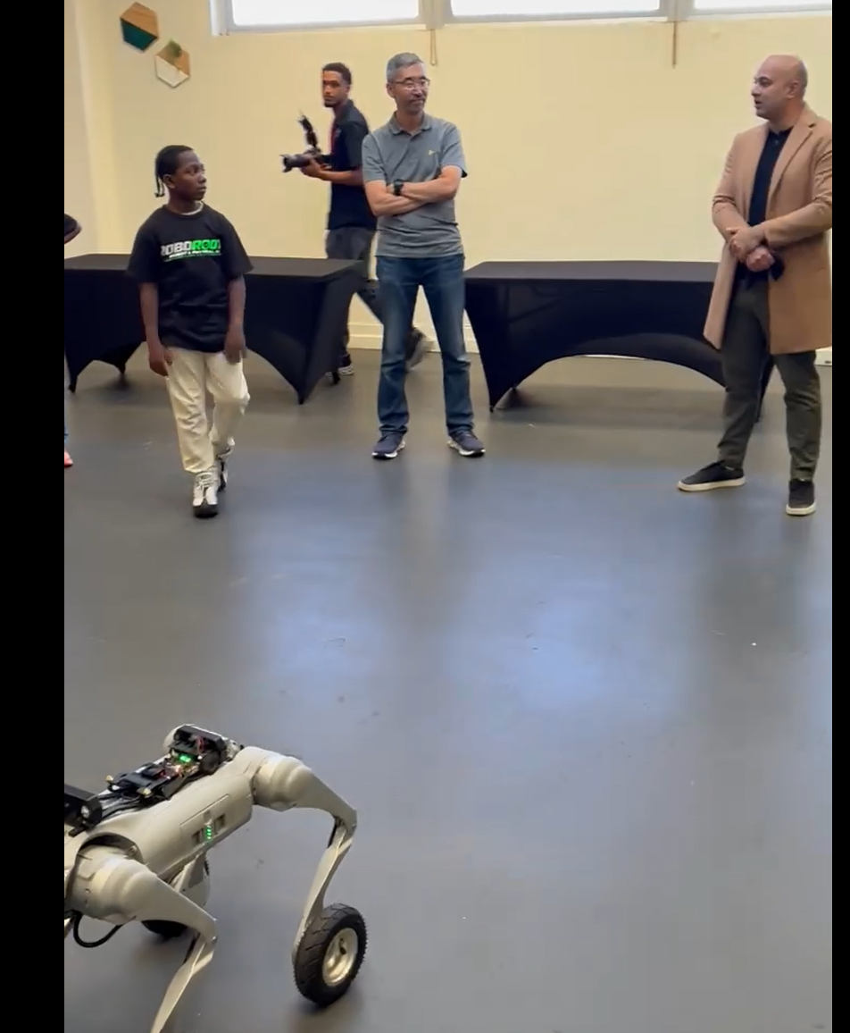 Supervisor Bilal Mahmood with student builders and a quadruped robot at AAACC